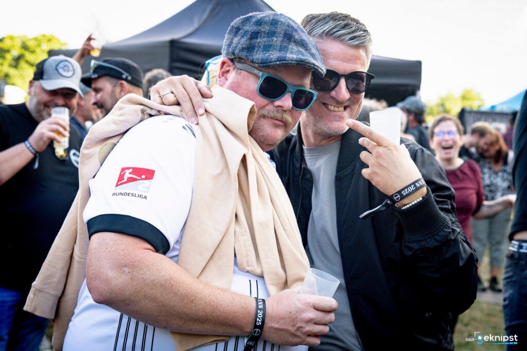 Männer feiern auf einem Festival mit Getränken.