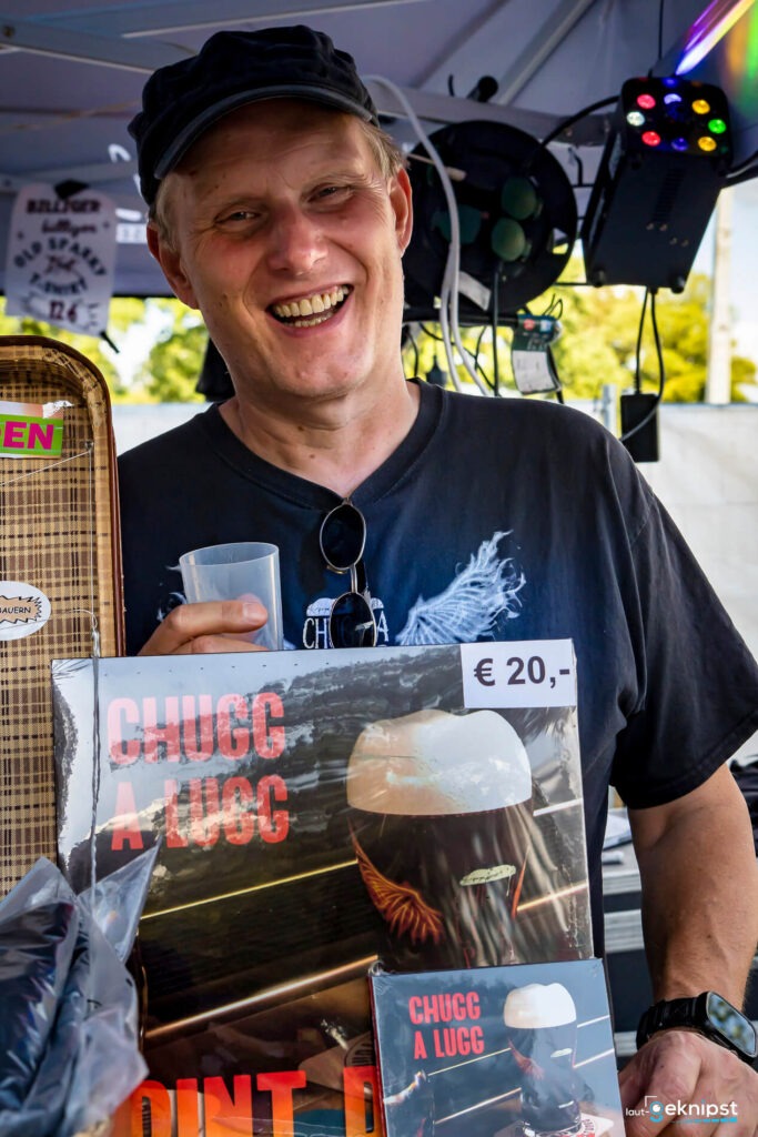 Verkäufer hält Vinylplatte auf einem Marktstand.
