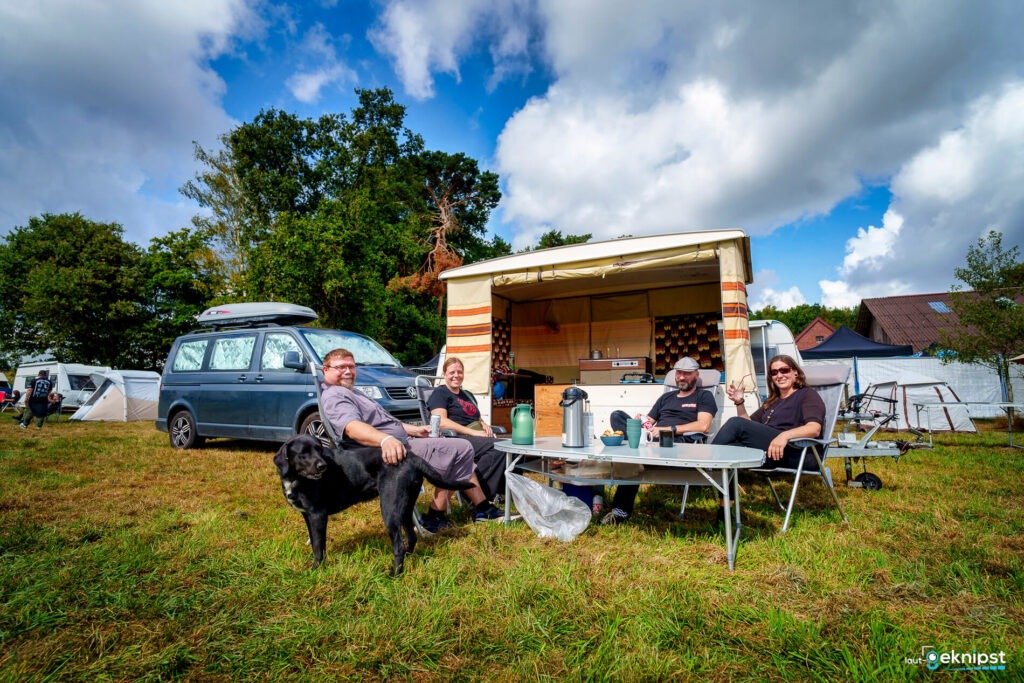 Gruppe beim Campen mit Hund und Tisch.
