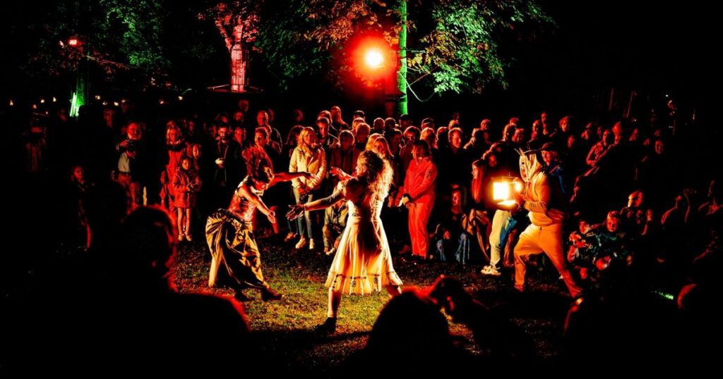 Nachtperformance mit Publikum im Freien, bunte Beleuchtung