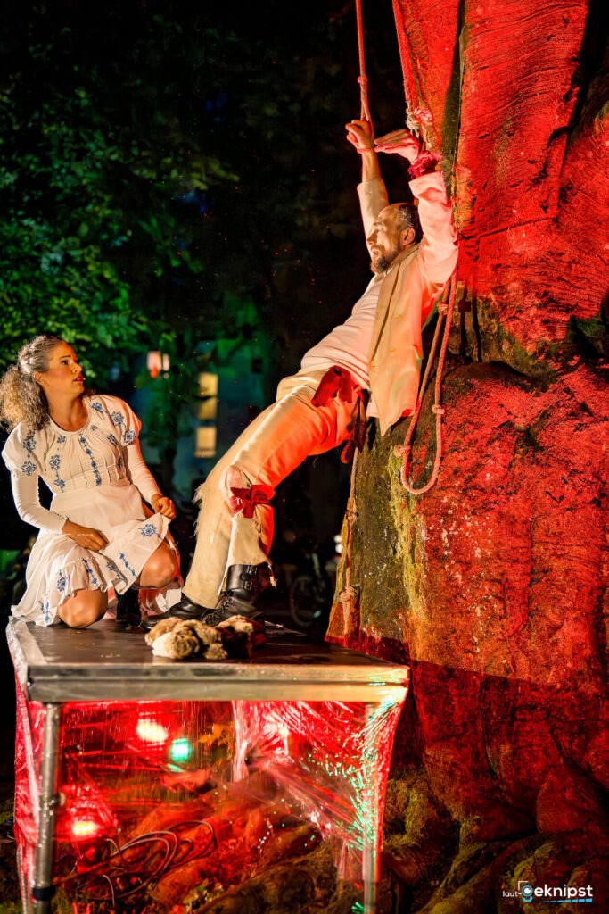 Zwei Personen bei einer Outdoor-Performance mit Lichteffekten.