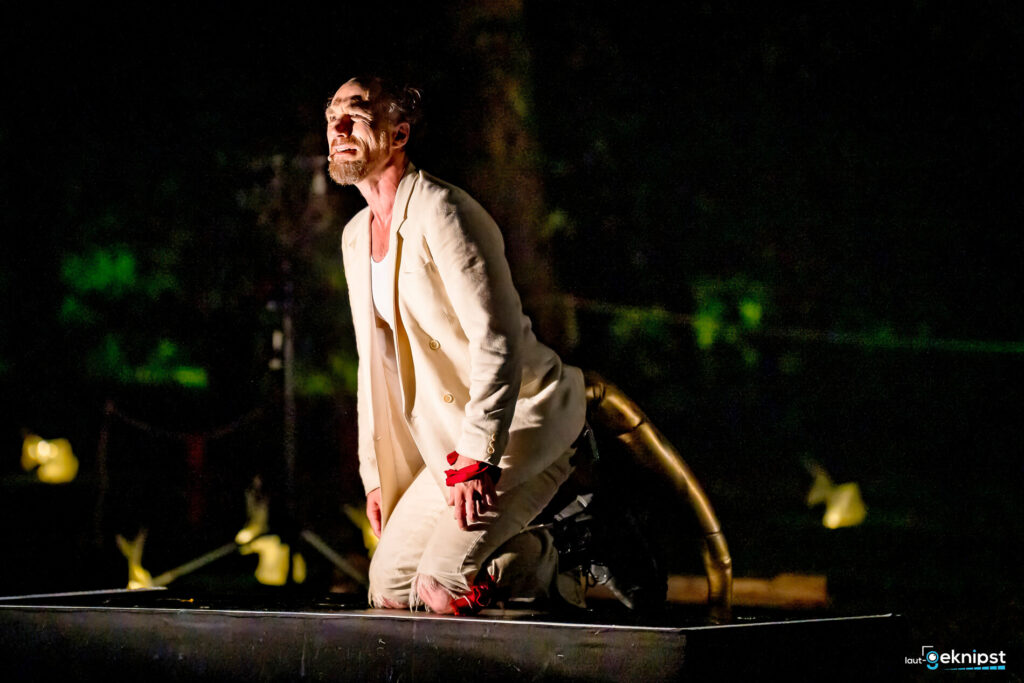 Schauspieler kniet auf Bühne, dramatischer Ausdruck