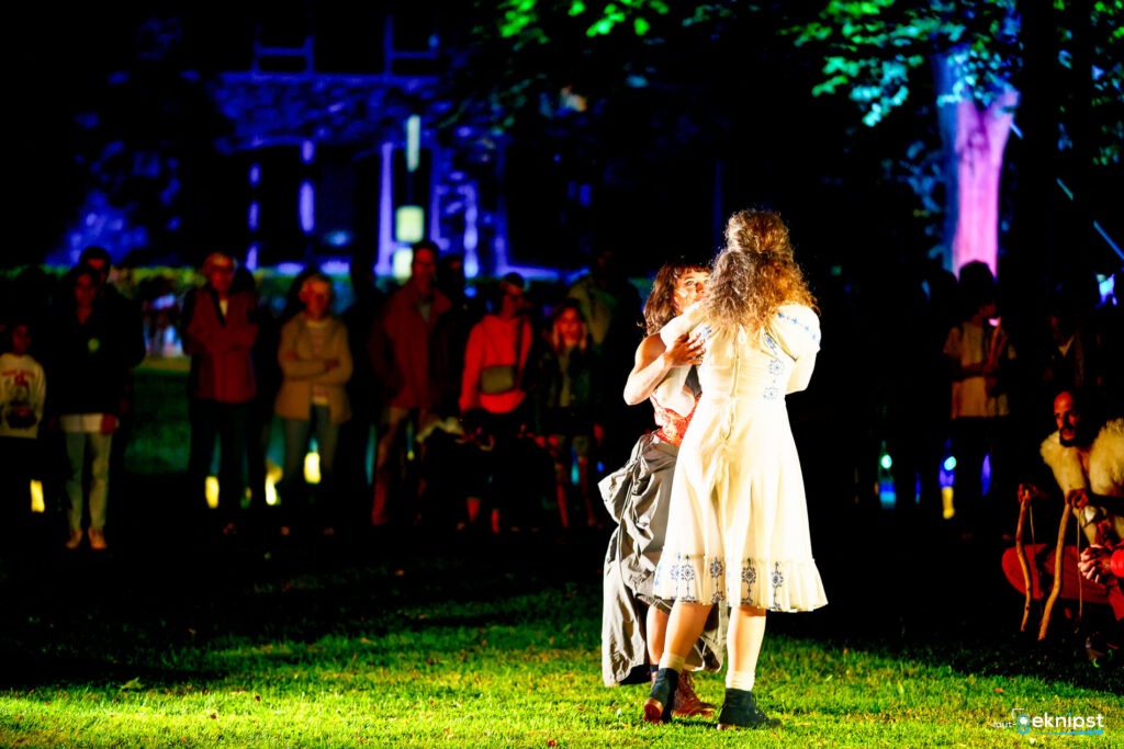Tanzperformance im Freien mit Publikum bei Nacht.