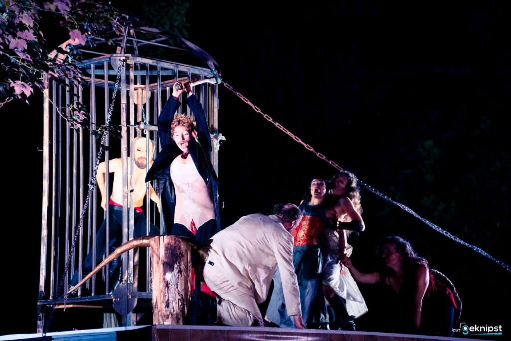 Theateraufführung mit Kostümen und Käfig