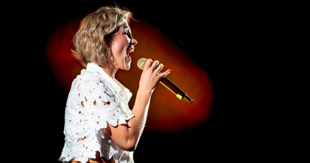 Anna Maria Zimmermann singt mit Mikrofon auf Bühne