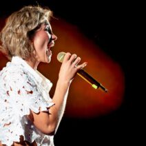 Anna Maria Zimmermann singt mit Mikrofon auf Bühne