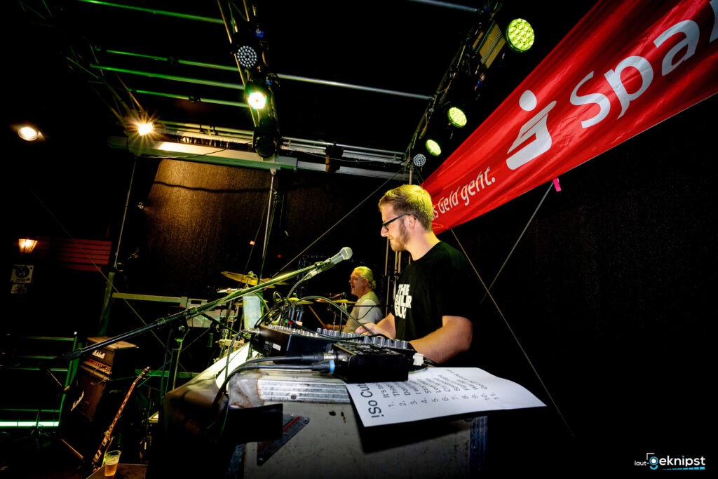 Mann bei Konzert hinter Mischpult auf Bühne