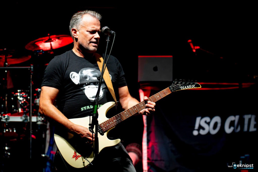 Musiker spielt E-Gitarre auf der Bühne.