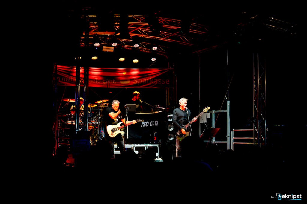 Band spielt auf einer Bühne mit Beleuchtung.