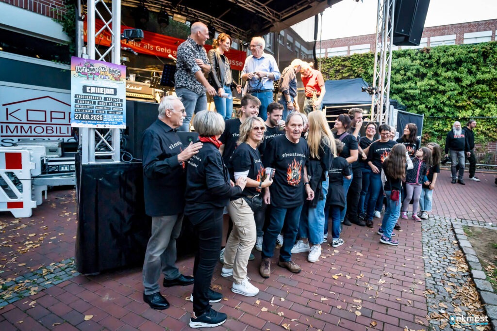 Gruppe von Menschen bei einer Veranstaltung auf einer Bühne.
