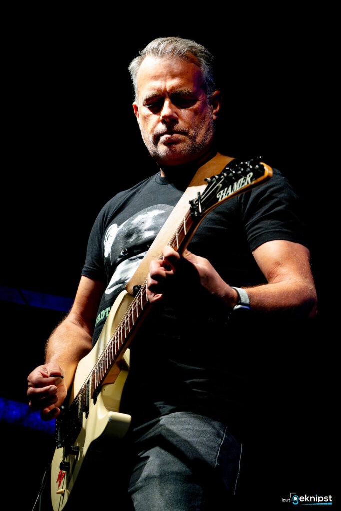 Mann spielt E-Gitarre auf der Bühne