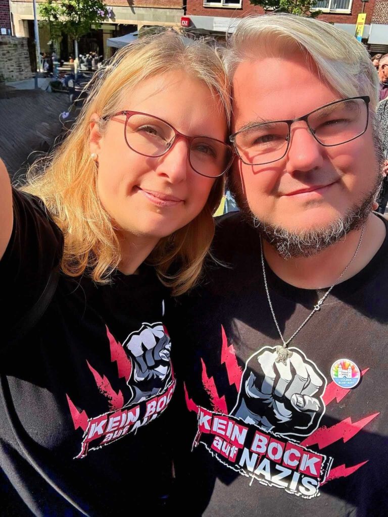 Zwei Personen mit Antifa-T-Shirts bei Sonnenschein.