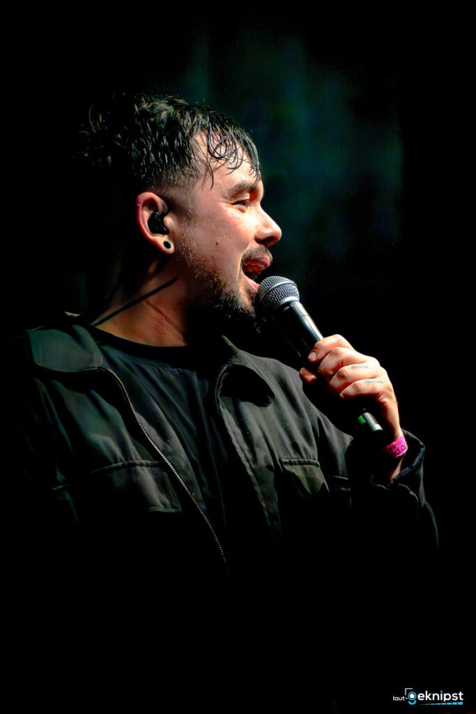 Mann singt auf der Bühne mit Mikrofon