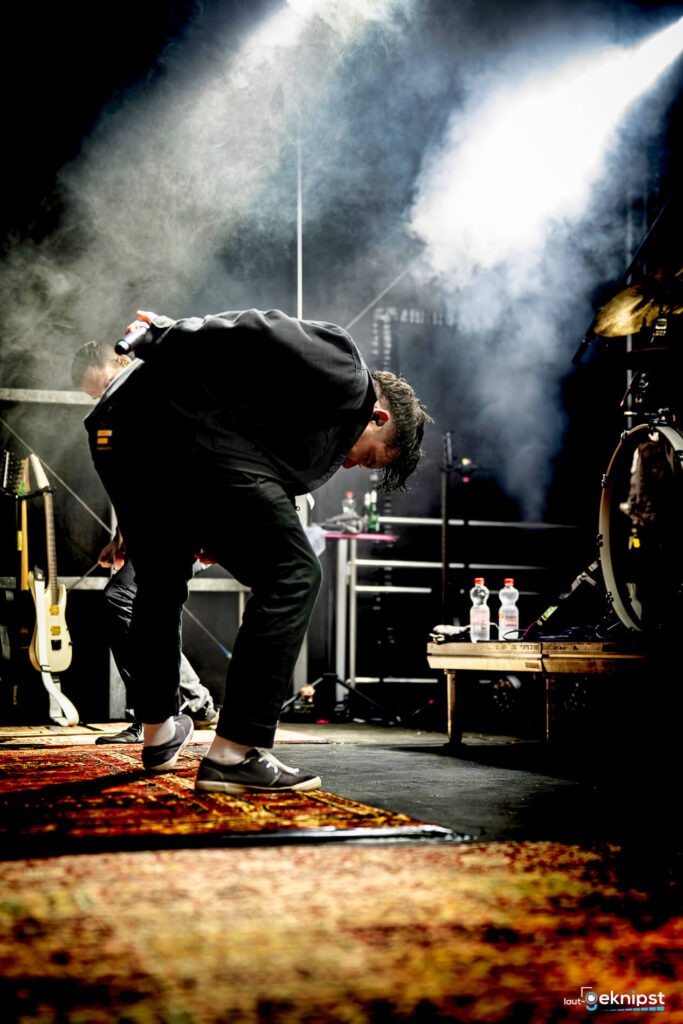 Mann auf Bühne verbeugt sich beim Konzert.