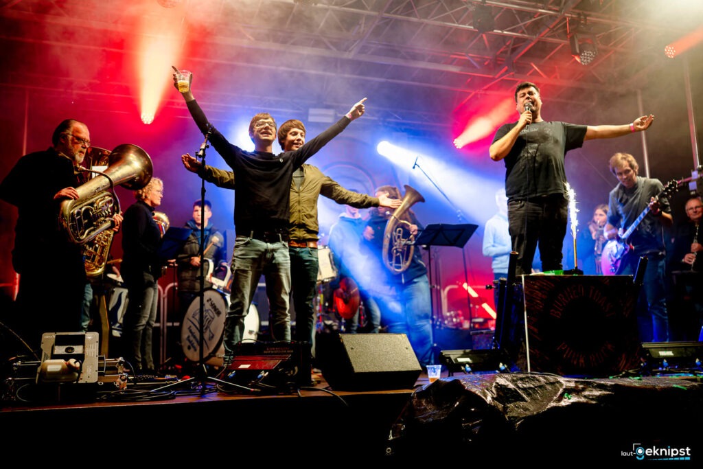 Musiker auf Bühne mit Lichtern und Instrumenten