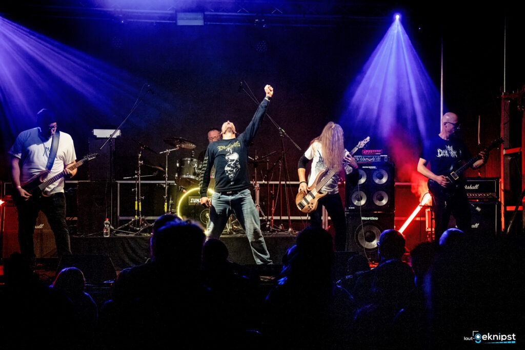 Rockband spielt live auf der Bühne mit Lichteffekten.