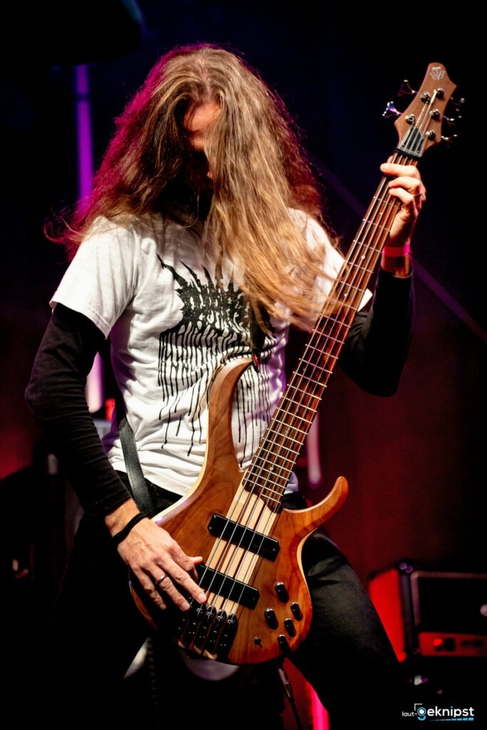 Bassist spielt energiegeladen auf der Bühne