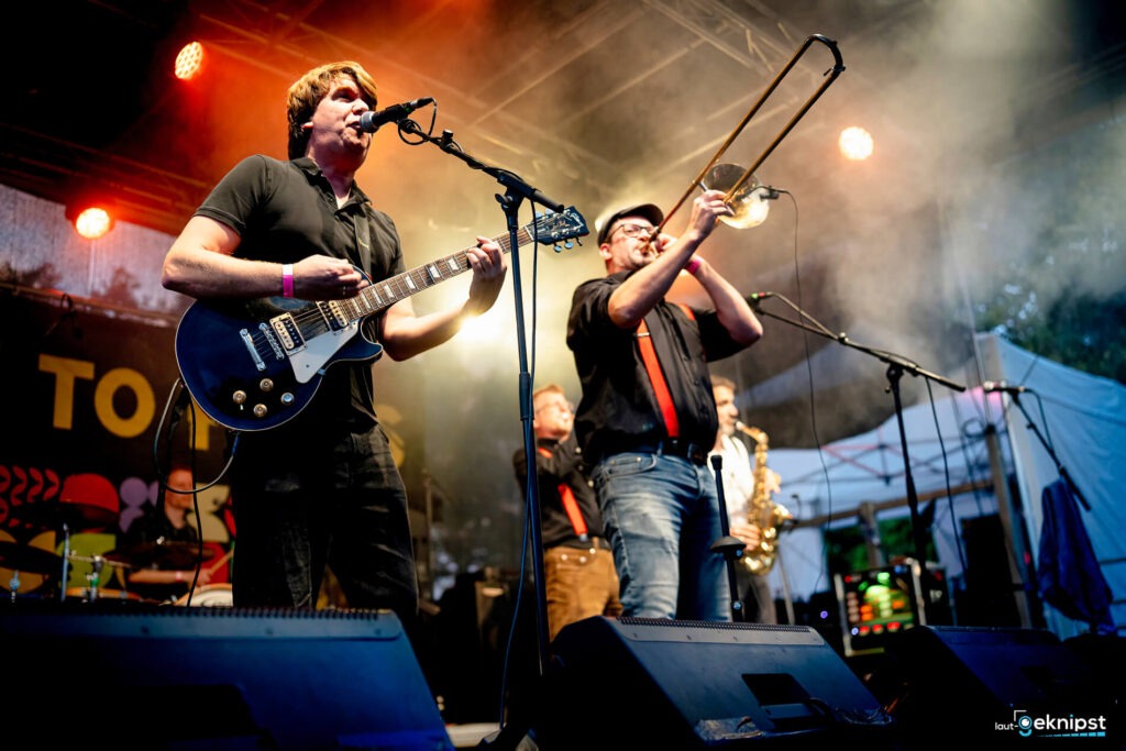 Band spielt live auf einer bunten Bühne.