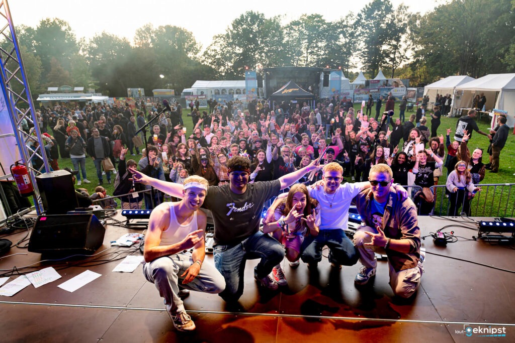 Band vor jubelndem Publikum auf Festivalbühne.