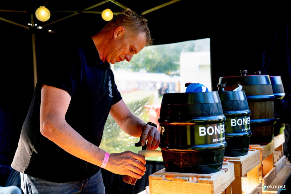 Mann zapft Bier aus Fass auf Festival.