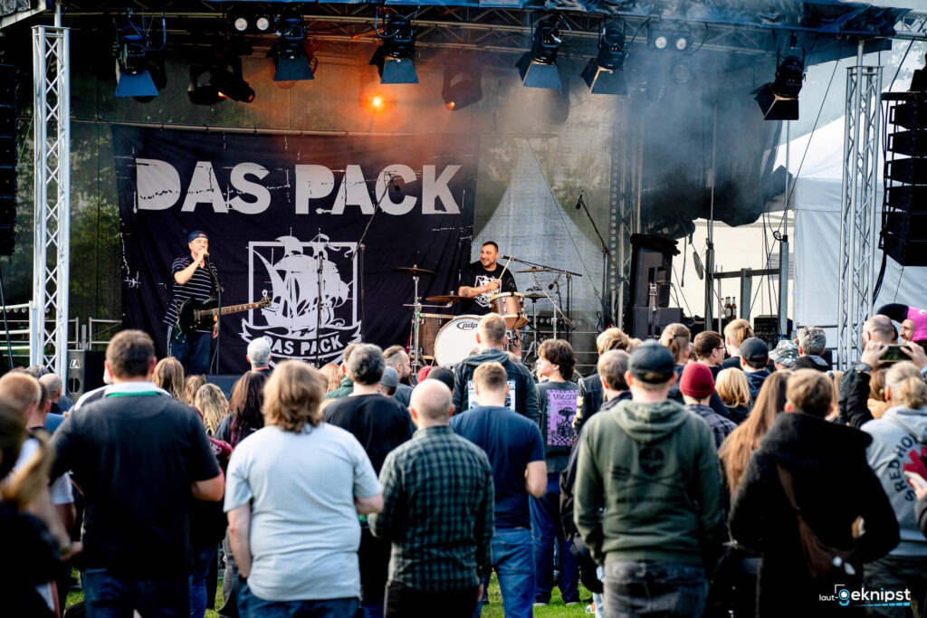 Live-Konzert mit Band auf der Bühne, Menschenmenge davor.