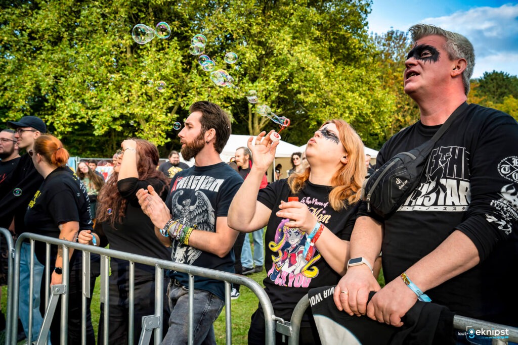 Menschen pusten Seifenblasen bei einem Festival.