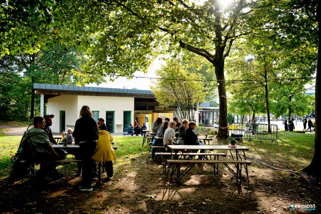 Menschen sitzen auf Bänken im grünen Park.