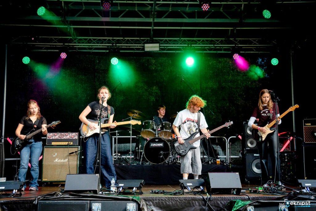 Junge Band spielt Live-Konzert auf Bühne.