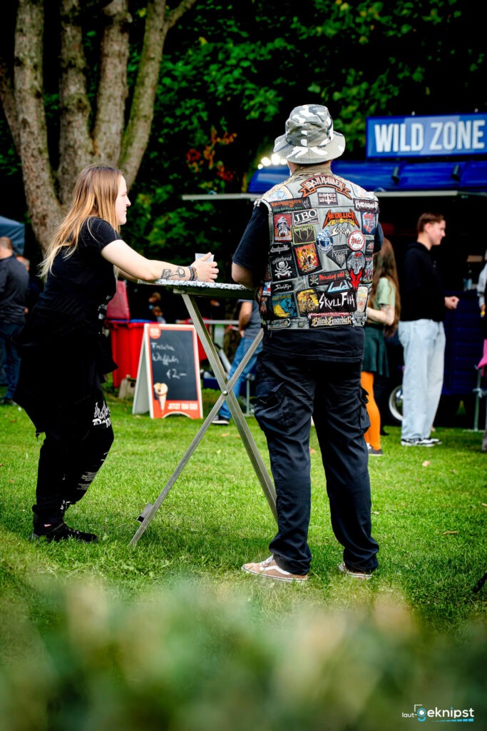 Menschen unterhalten sich bei einem Festival im Freien.