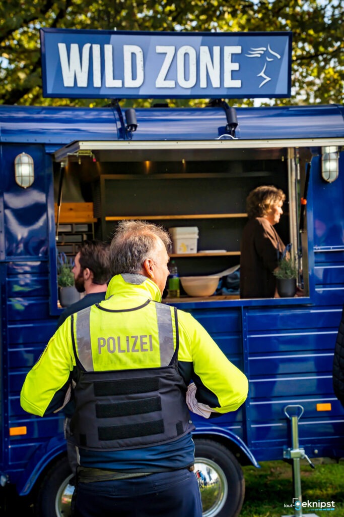 Polizist vor mobilem Imbisswagen