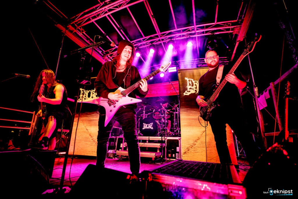 Live-Band auf Bühne mit Gitarren und Schlagzeug.