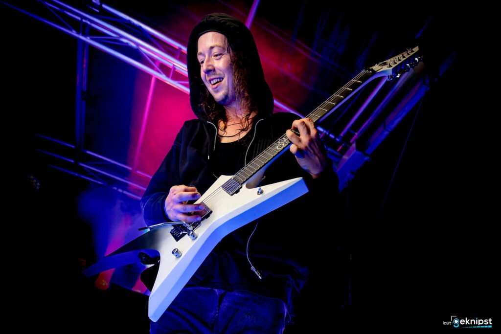 Gitarrist mit weißer Gitarre auf der Bühne
