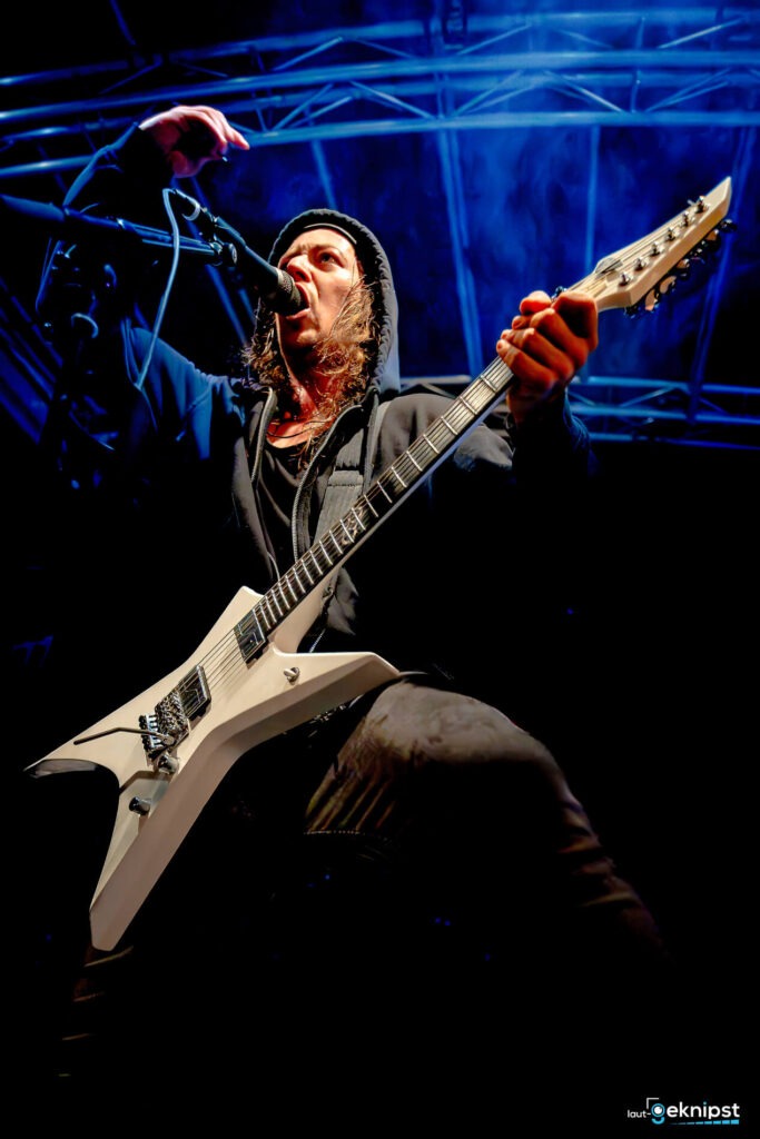 Musiker spielt E-Gitarre auf der Bühne.