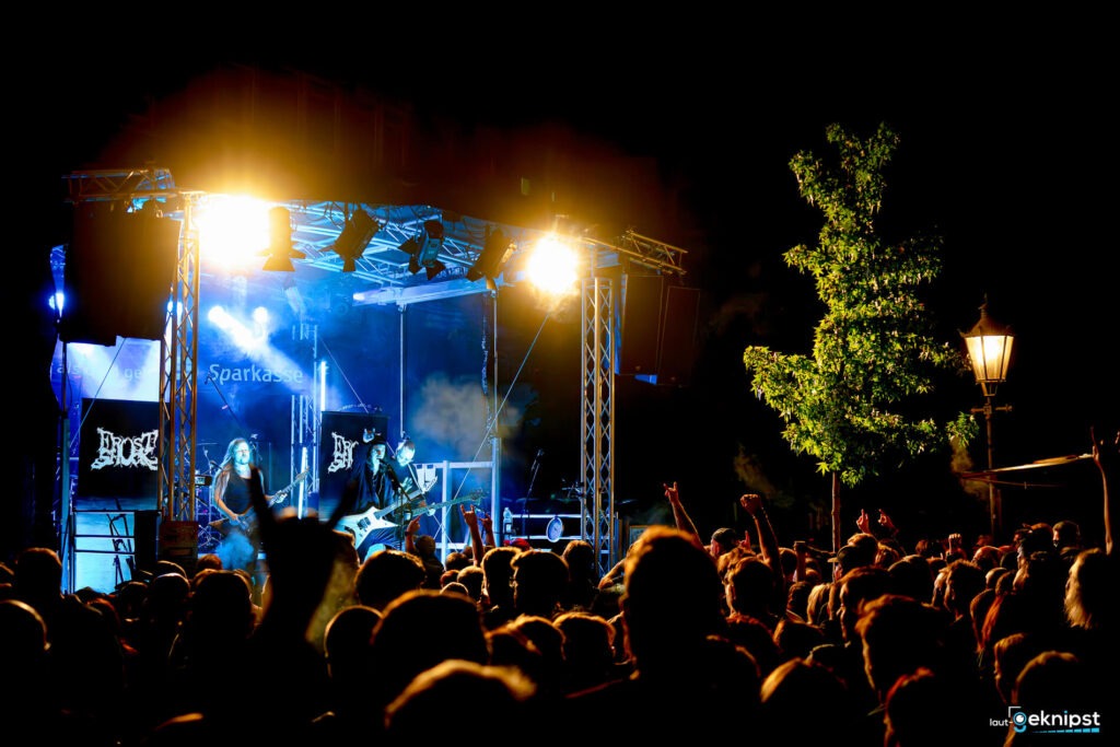 Nachtkonzert mit bunter Bühne und begeistertem Publikum.