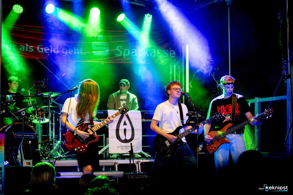 Band spielt auf Bühne mit Lichteffekten