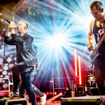 Live-Rockband auf der Bühne mit Lichteffekten.