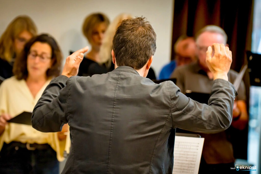 Dirigent leitet Chorprobe mit Partitur