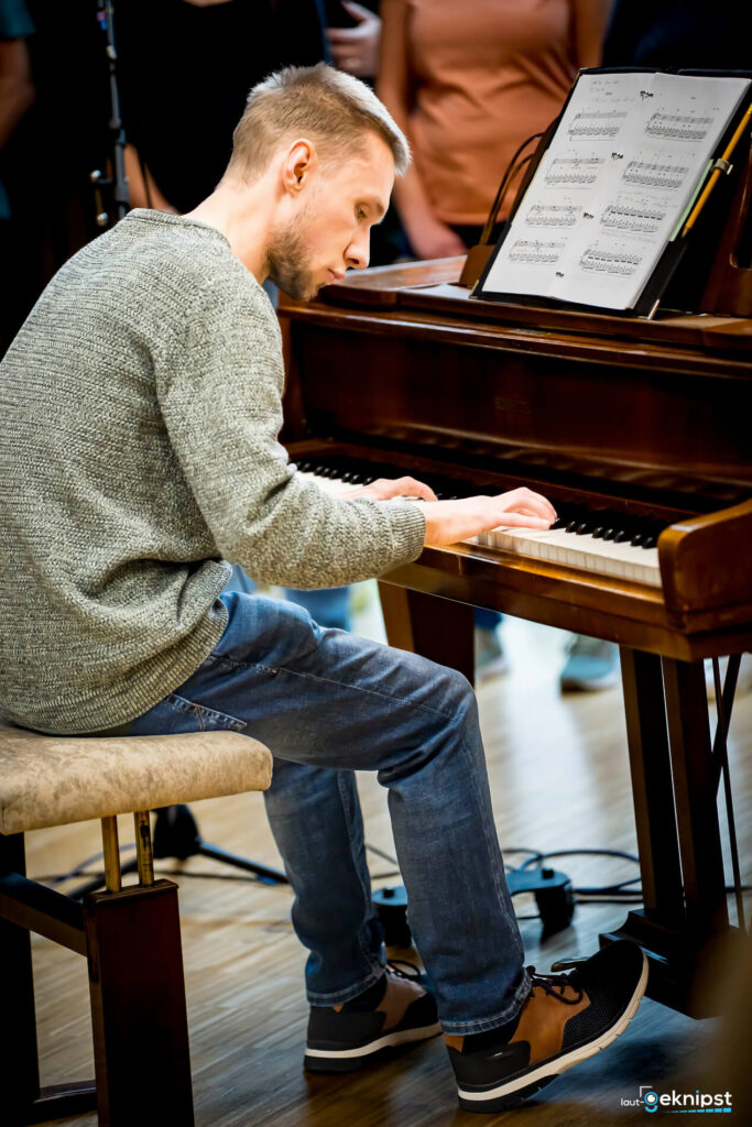 Mann spielt Klavier vor Publikum