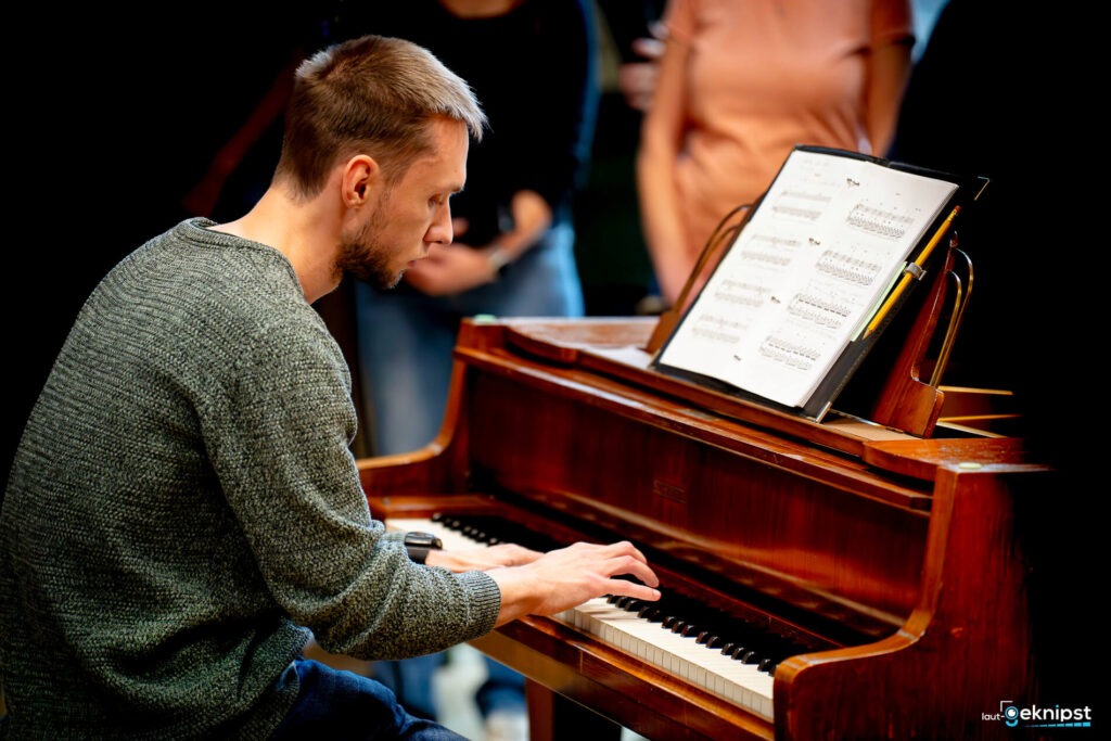 Mann spielt Klavier mit Notenblatt