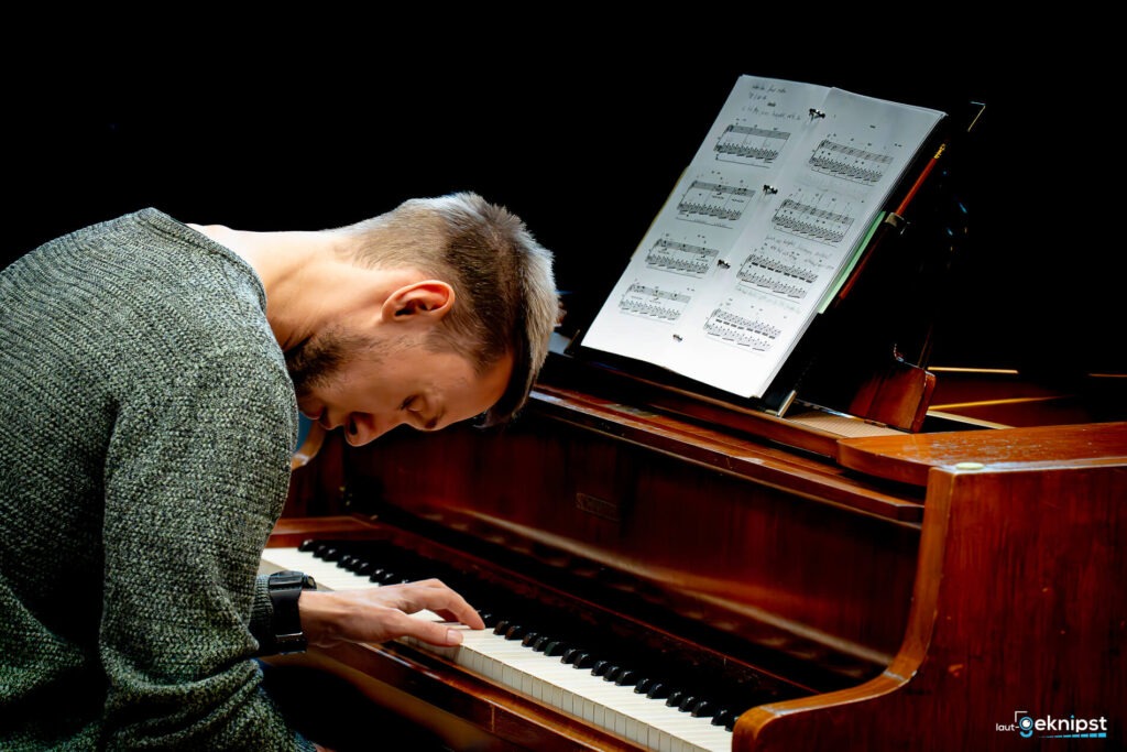 Mann spielt Klavier und liest Noten