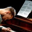 Mann spielt Klavier mit Notenblatt