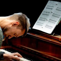 Mann spielt Klavier mit Notenblatt