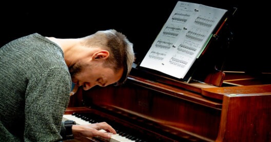 Mann spielt Klavier mit Notenblatt