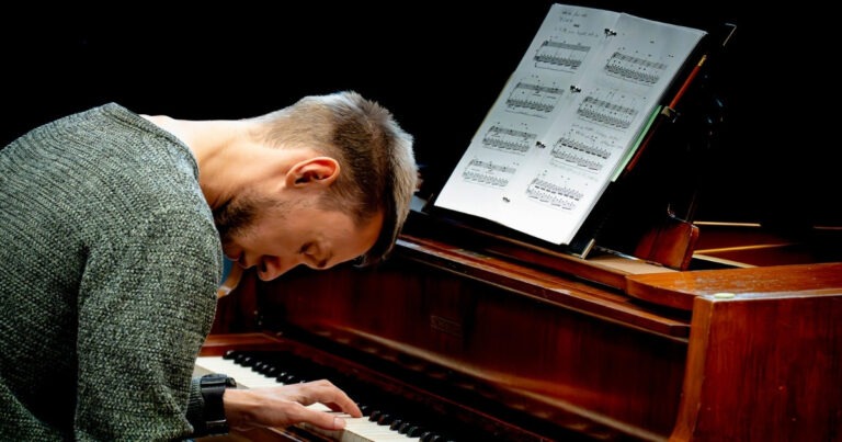 Mann spielt Klavier mit Notenblatt