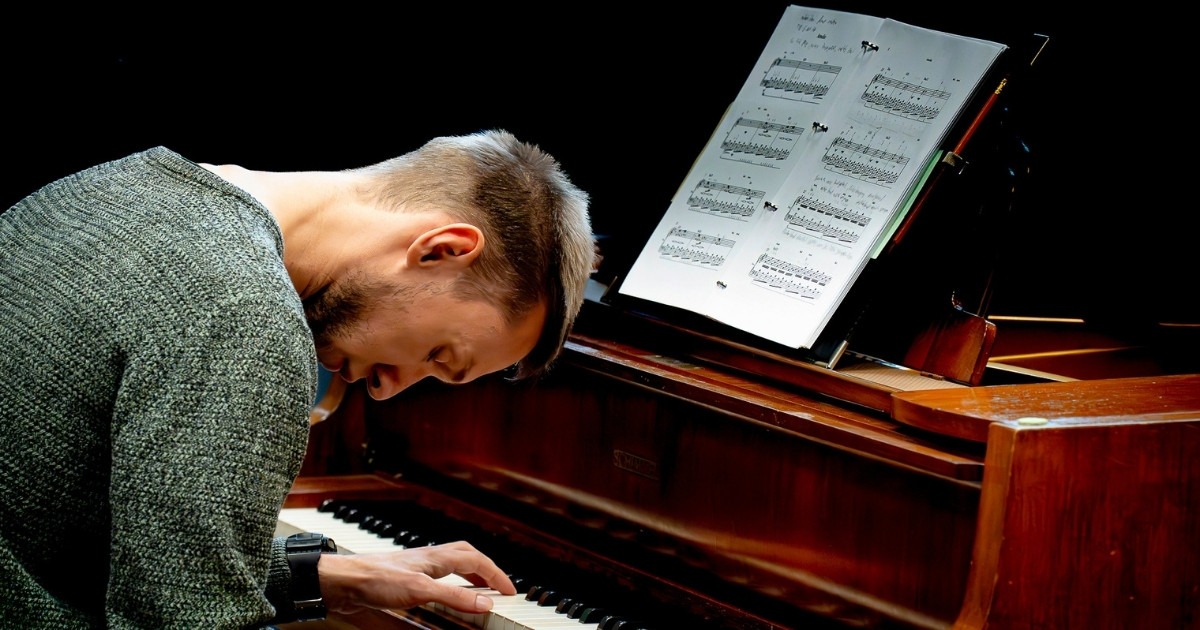Mann spielt Klavier mit Notenblatt