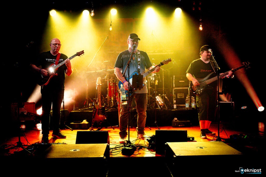 Band tritt live auf einer Bühne auf.