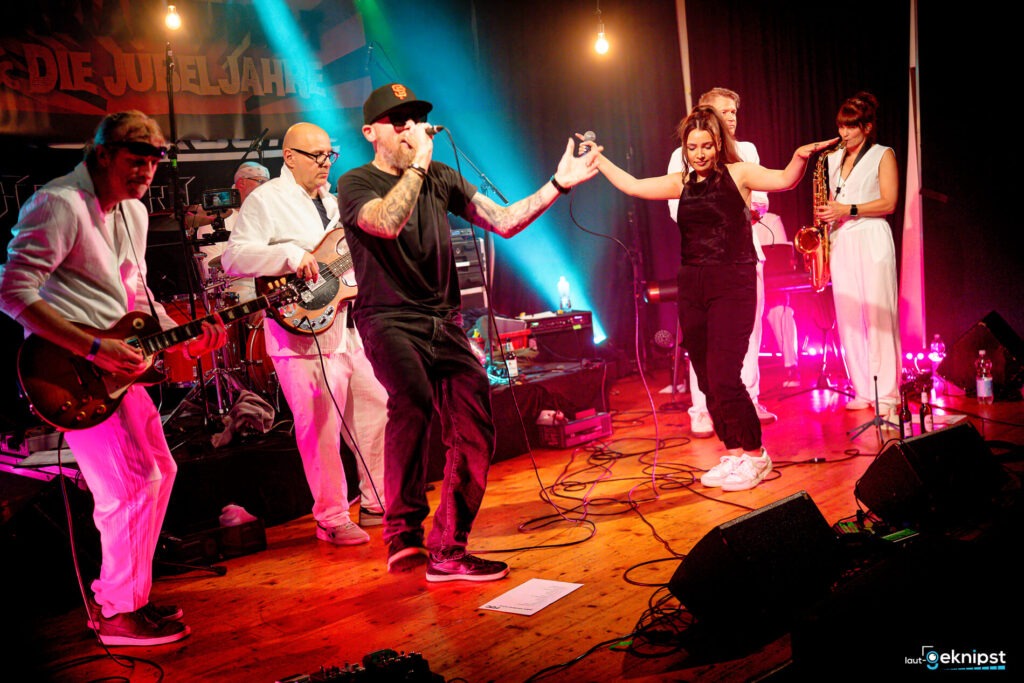 Bandauftritt mit fünf Musikern auf der Bühne.