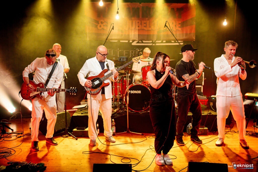 Band spielt Live-Musik auf Bühne mit Instrumenten.