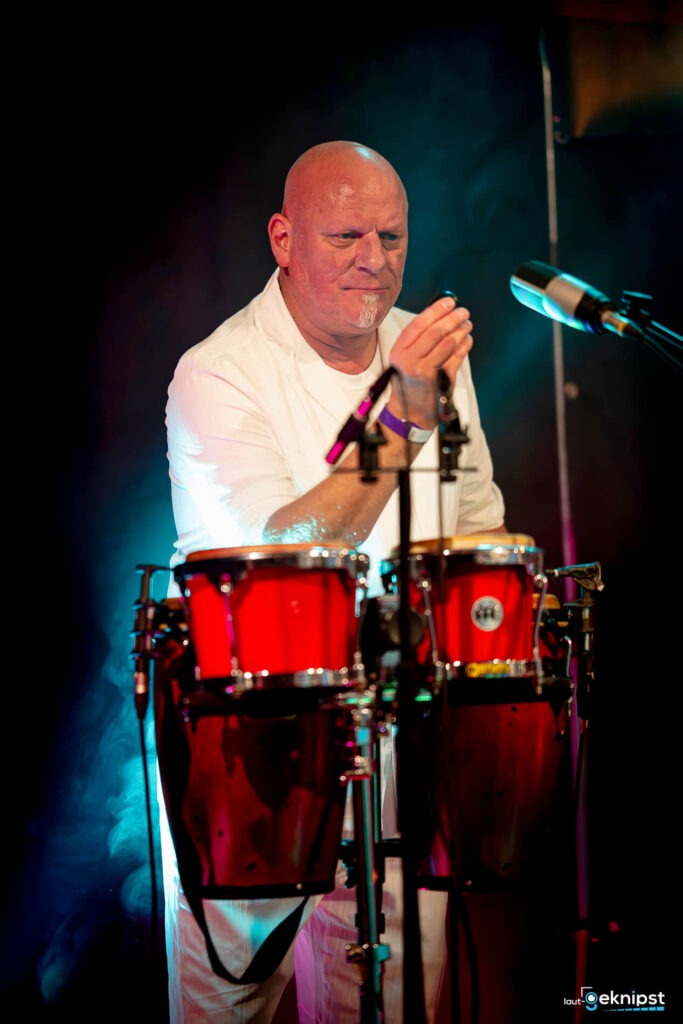 Mann spielt rote Congas auf Bühne