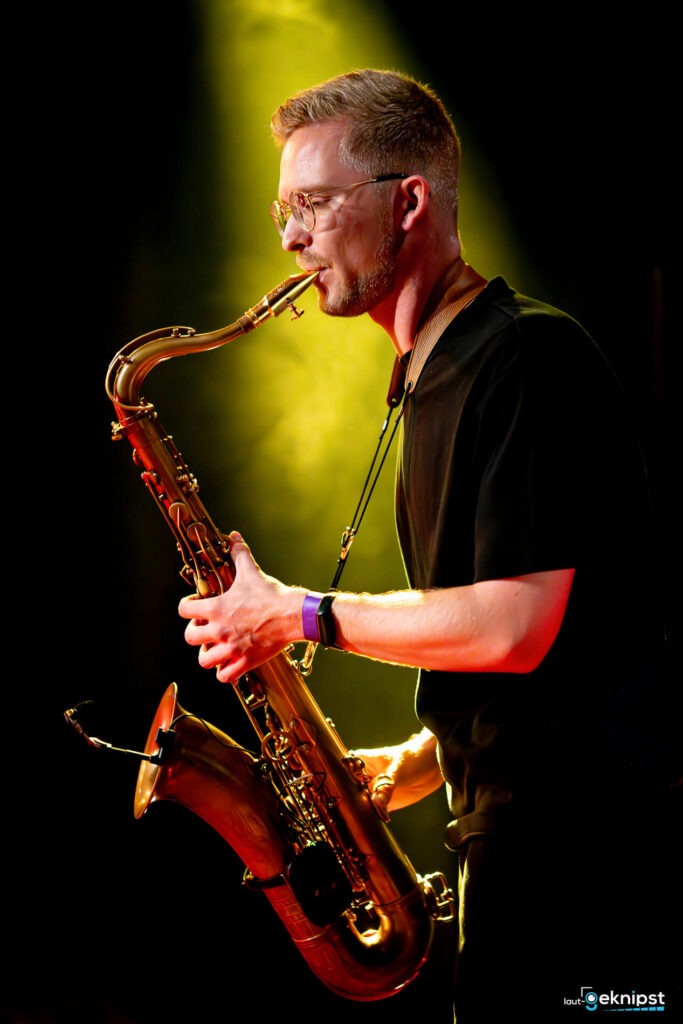 Mann spielt Saxophon auf der Bühne